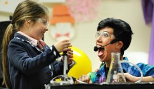 A happy child and excited adult working on a science experiment together